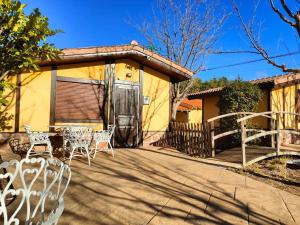 un patio con mesas y sillas frente a una casa en Masia Del Cura en Rubielos de Mora