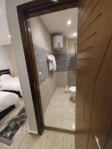 a bathroom with a walk in shower next to a bed at Zoser Pyramids View- Foreiigners only in Cairo
