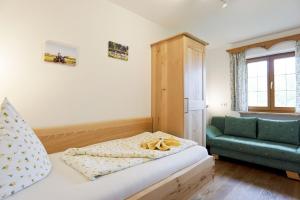 a small bedroom with a bed and a green chair at Wagnerhof in Au am Inn +22 photos