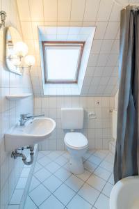 ein Bad mit einem WC, einem Waschbecken und einem Fenster in der Unterkunft NEU! Kaptän Hook Stube (OG) Hooksiel in Hooksiel