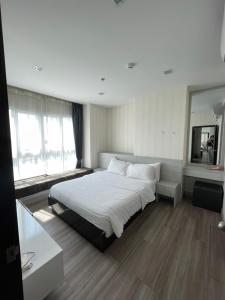a bedroom with a large bed and a mirror at The One Prio Residence in Chiang Mai