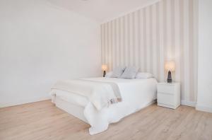 - une chambre blanche dotée d'un lit blanc avec des draps et des oreillers blancs dans l'établissement Marbella center Casals, à Marbella