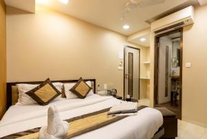 um quarto com uma cama num quarto em The Majlis Hotel - Colaba Mumbai em Mumbai