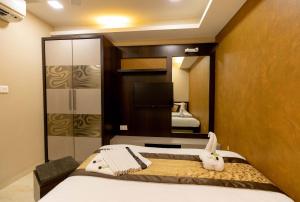 a hotel room with a bed and a tv at The Majlis Hotel - Colaba Mumbai in Mumbai