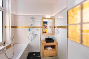 La salle de bains est pourvue d'une baignoire, d'un lavabo et d'une douche. dans l'établissement Hotel Kleiner Riesen, à Coblence