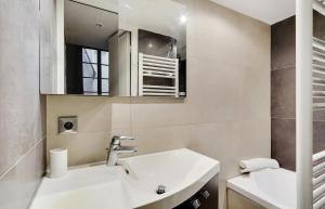 a bathroom with a sink and a mirror at Paris Marais Ville de Verre in Paris