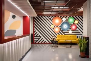a lobby with a yellow couch and balloons on the wall at BYPILLOW Crosstown in Madrid