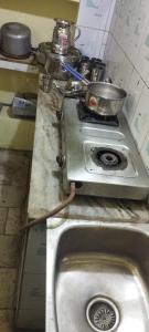 encimera de cocina con fogones y fregadero en Sri Viswanatham Guest House en Varanasi
