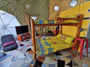a bedroom with two bunk beds and a tv at Glamping Dome Dauin Beach and Dive Resort in Dauin