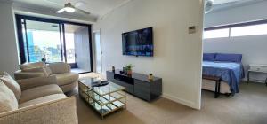 a living room with a couch and a bed at Room in shared apartment in Fortitude Valley in Brisbane