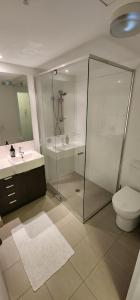 a bathroom with a shower and a toilet and a sink at Room in shared apartment in Fortitude Valley in Brisbane