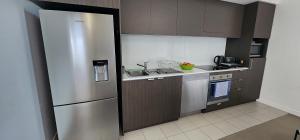 a kitchen with a stainless steel refrigerator and a sink at Room in shared apartment in Fortitude Valley in Brisbane
