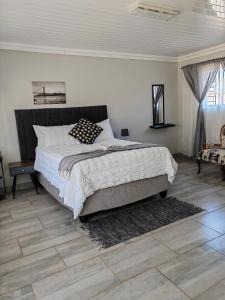 a bedroom with a large bed and a wooden floor at Back of the Moon Guesthouse in Kuruman
