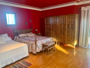 um quarto com 2 camas e uma parede vermelha em LUXURY Positive House Gran Chaparral Toledo em Pepino