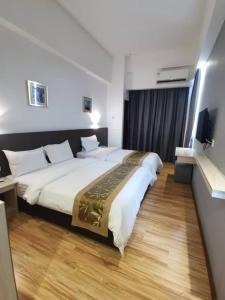 a hotel room with a large bed and a television at Sentral View Hotel Bintulu in Bintulu