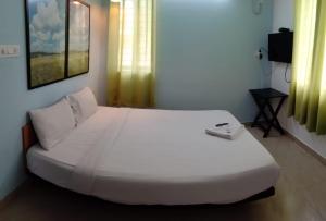 XTEND INNS في إرناكولام: سرير أبيض كبير في غرفة بها