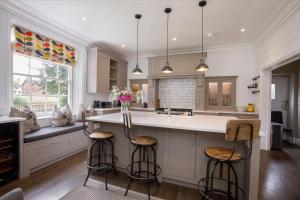 a kitchen with white cabinets and bar stools at Prospect House in York