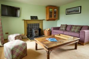 a living room with a couch and a fireplace at Balnakeil Cattleman's Bothy in Durness
