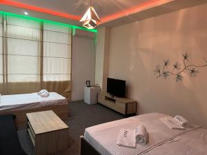 科布列季KENT hotel & Restaurant KENT beach的一间有两张床和一台电视的酒店房间