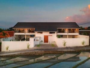 une maison blanche avec un toit noir dans l'établissement *Luxury Astaga Villa 2*Modern*Billiard*Paddy View*, à Canggu