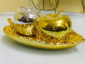 two gold apples on a plate on a table at Luanda City Hostel in Luanda