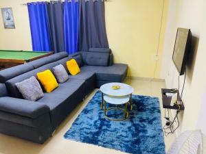 sala de estar con sofá azul y almohadas amarillas en Luanda City Hostel, en Luanda