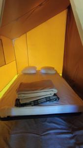 a bed in a tent with a pile of towels at Camping Onlycamp De La Varenne in Neung-sur-Beuvron +5 photos