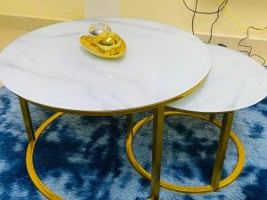 uma mesa branca com pernas douradas e um anel. em Luanda City Hostel em Luanda