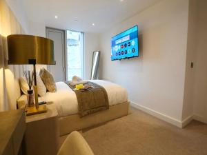 a bedroom with a bed and a tv on a wall at Pass the Keys Central 3x King Bed Suite 5 Min Deansgate Station in Manchester