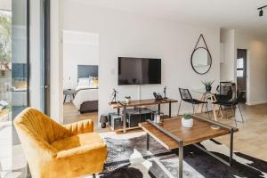 a living room with a couch a chair and a tv at 207 Le Jardin in George
