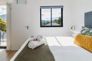 a white bedroom with a bed and a window at 207 Le Jardin in George +18 photos