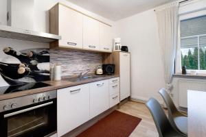 a kitchen with white cabinets and a stove at Vogelsberger Bett 5 die 2 links in Alsfeld