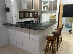 eine Küche mit einer Theke und 2 Hockern in der Unterkunft Recanto do jao in Maragogi
