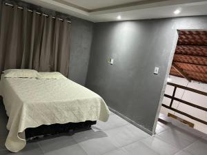 ein Schlafzimmer mit einem Bett und einer grauen Wand in der Unterkunft Recanto do jao in Maragogi