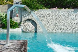 a water fountain in the middle of a swimming pool at Hotel Botanico San Lazzaro in Maiori
