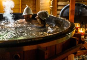 a couple of people in a bath tub at Domki Letniskowe Forest nad morzem in Darłowo