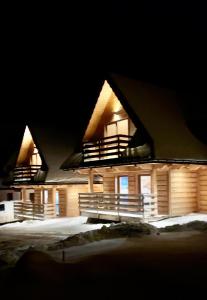 a large wooden house at night in the snow at Domek na Szlaku koło ZAKOPANEGO in Bańska Niżna