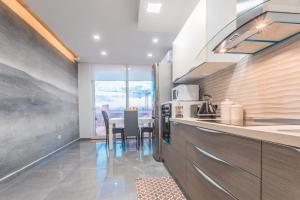 a kitchen with a table and a dining room at Chic Retreat in the Heart of Tigne Sliema in Sliema