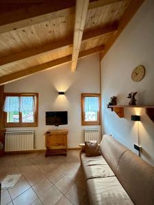 ein Wohnzimmer mit Sofa und Fernseher in der Unterkunft Auronzo - Appartamento centrale vista mozzafiato con garage in Auronzo di Cadore