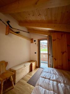 een slaapkamer met een bed en een groot raam bij Auronzo - appartamento centrale vista mozzafiato in Auronzo di Cadore