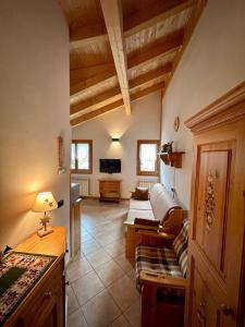 een woonkamer met een bank en een tv bij Auronzo - appartamento centrale vista mozzafiato in Auronzo di Cadore