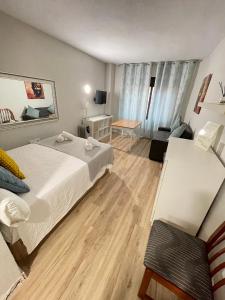 a hotel room with two beds and a desk at Resitur Luxury Suit A in Seville