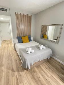 1 Schlafzimmer mit 2 Betten und einem großen Spiegel in der Unterkunft Resitur Luxury Suit A in Sevilla
