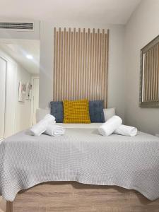 ein Schlafzimmer mit einem großen weißen Bett und einem gelben Kissen in der Unterkunft Resitur Luxury Suit A in Sevilla