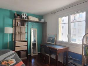 Schlafzimmer mit einem Schreibtisch, einem Bett und einem Fenster in der Unterkunft Chambre privée au calme chez l'habitant in Montrouge
