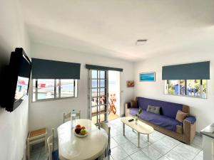 salon z niebieską kanapą i stołem w obiekcie Atico de 2 dormitorios con vista al Mar, a 100 m de playa w mieście Puerto de la Estaca