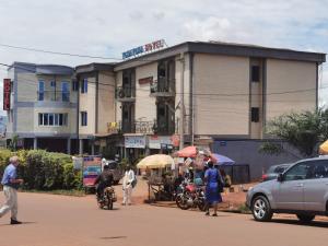 a group of people walking down a street in front of a building at TCHATCHA HOTEL in Yaoundé