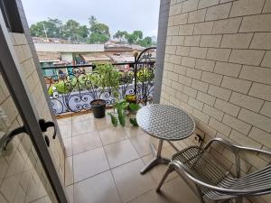 een patio met een tafel en stoelen op een balkon bij TCHATCHA HOTEL in Yaoundé