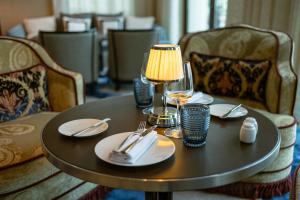 a table with a lamp and plates and glasses on it at Four Seasons Hotel Tunis in Gammarth