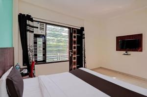 1 dormitorio con 1 cama y ventana con TV en Hotel Imperial, en Greater Noida